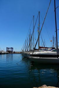 Sailboats in sea against clear blue sky