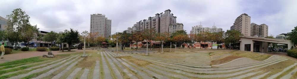 Panoramic view of trees and buildings against sky