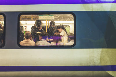 People traveling in train seen from window