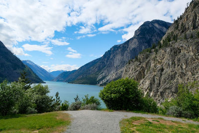 Scenic view of lake by mountains against sky