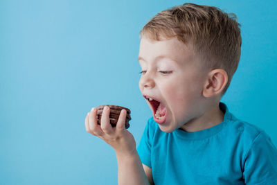 Portrait of boy against blue background