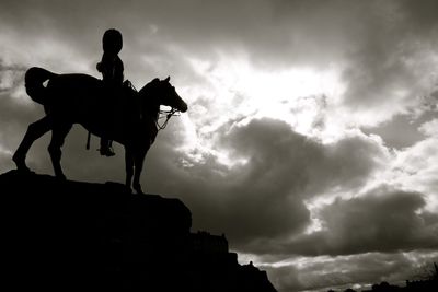 Low angle view of silhouette man against cloudy sky