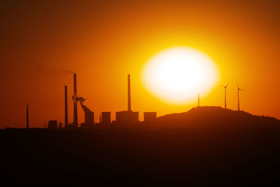 Silhouette of power station at sunset