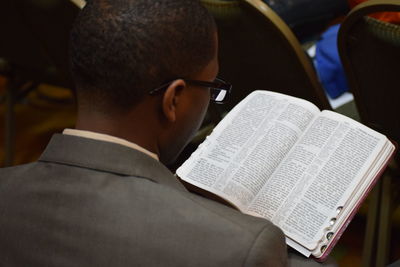 Rear view of man reading bible in church