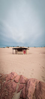 Lifeguard hut on beach against sky