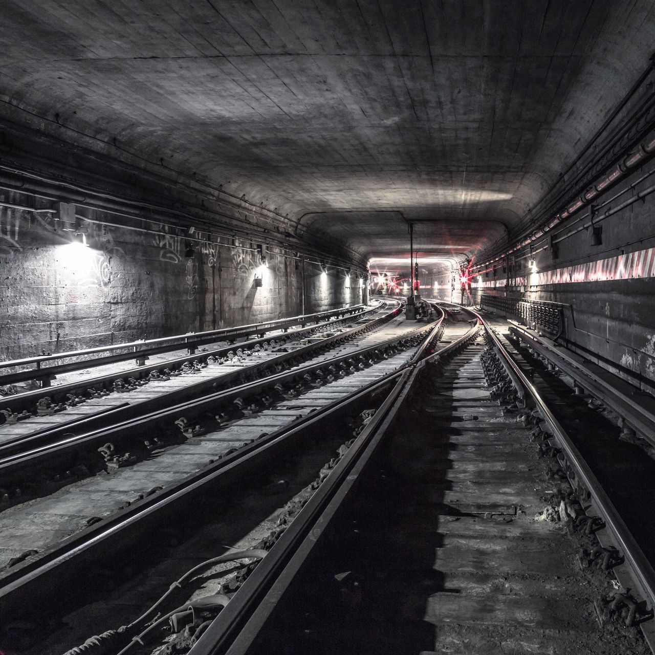 railroad track, transportation, indoors, rail transportation, the way forward, illuminated, diminishing perspective, railroad station platform, public transportation, ceiling, railroad station, tunnel, vanishing point, built structure, lighting equipment, architecture, travel, incidental people, empty, subway