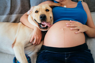 Midsection of woman touching dog