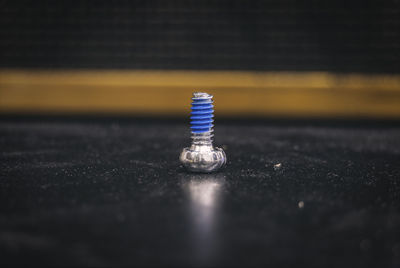 Close-up of screw on black table