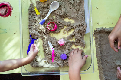 Cropped hand of kid playing with sand