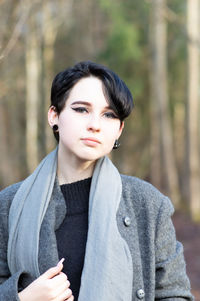 Portrait of young woman wearing warm clothing while standing in forest