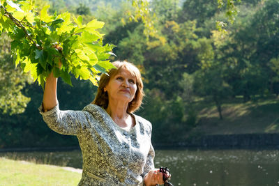 Portrait of a smiling young woman against lake