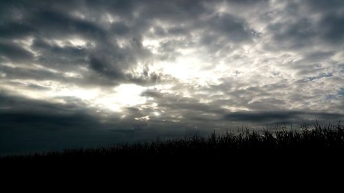 Silhouette of landscape against cloudy sky