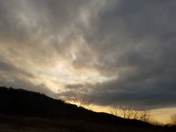 Silhouette of landscape against cloudy sky