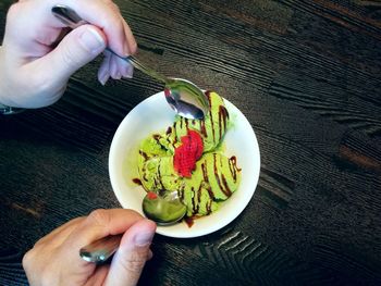 Cropped hands having dessert at table