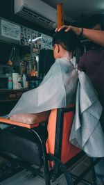 Boy sitting on chair at home