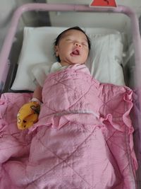 High angle view of baby boy sleeping on bed at home