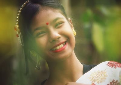 Portrait of smiling girl wearing jewelry at park