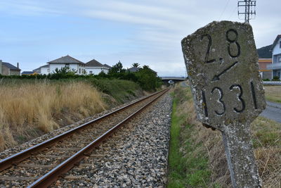 Railroad tracks amidst field against sky