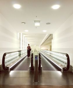 Woman on moving walkway in building