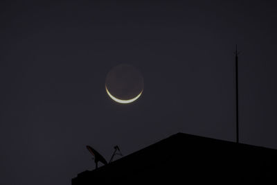 Low angle view of silhouette moon against sky at night