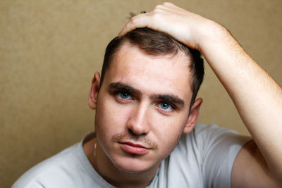 Portrait of a young brunette caucasian man on yellow background posing. handsome caucasian young man