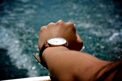 Cropped hand of person wearing wristwatch