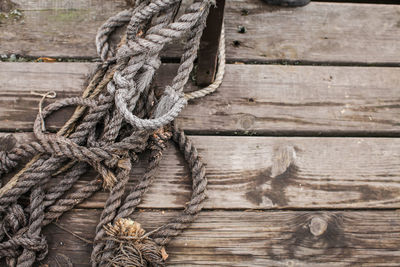 Close-up of rope tied to wooden pier