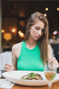 Portrait of young woman sitting at restaurant