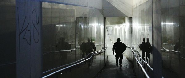 Silhouette man walking at underground walkway