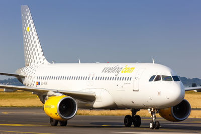 Airplane on airport runway against sky