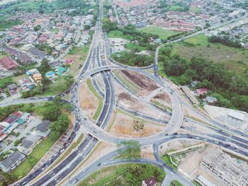 High angle view of road amidst trees and buildings in city