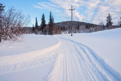 Winter landscape with a ski road between the snowdrifts and the setting sun.