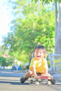 Cute boy sitting on toy against blurred background