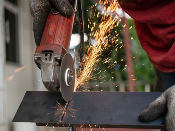 Close-up of person working on metal