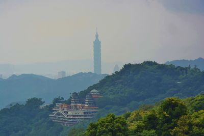 View of building and trees against sky