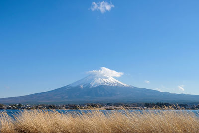 Scenic view of snowcapped mountains against blue sky