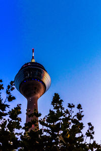 Low angle view of communication tower against blue sky