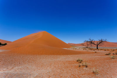 Scenic view of desert against clear blue sky