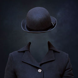 Digital composite image of invisible man wearing hat against black background