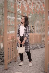 Portrait of young woman standing in city