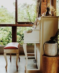 Seat by piano against window at home