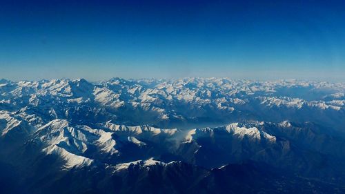 Scenic view of snowcapped mountains against blue sky