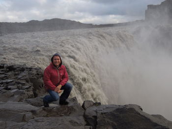 Portrait of man sitting on rock