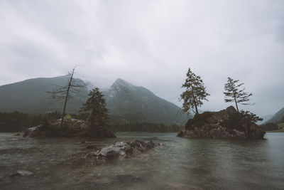 Scenic view of river by mountains against sky