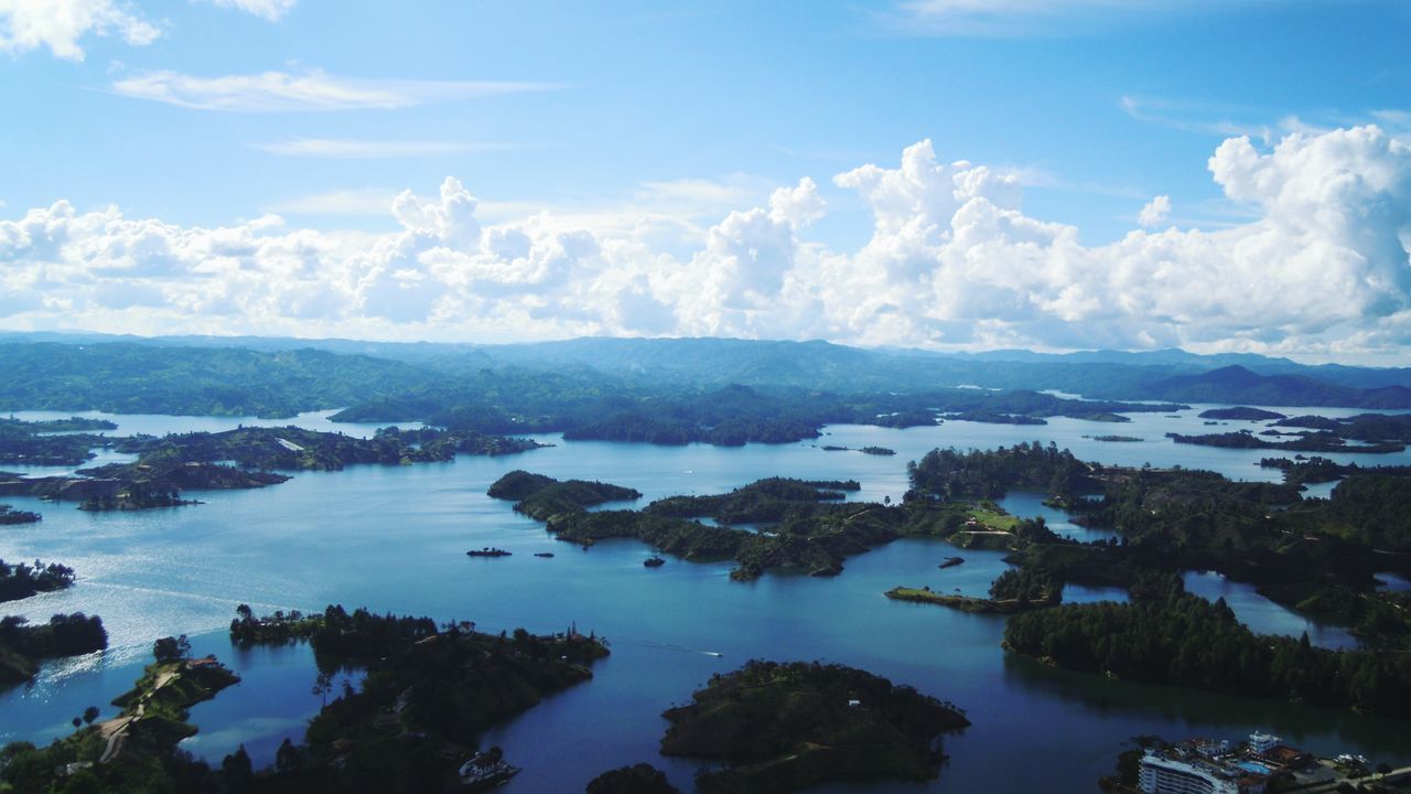 water, sky, mountain, scenics, tranquil scene, tranquility, beauty in nature, cloud - sky, sea, nature, lake, mountain range, cloud, high angle view, idyllic, tree, blue, waterfront, outdoors, day