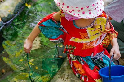 Little girl is playing at the small water tunnel. barefoot