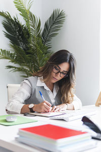 Young advocate making notes in office