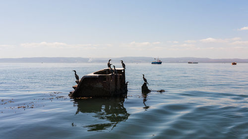 Boat moored on sea against sky