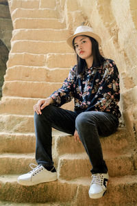 Full length of teenage girl sitting on staircase