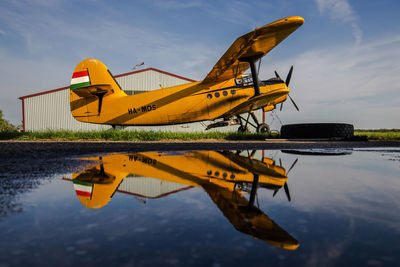 Yellow boat on lake against sky